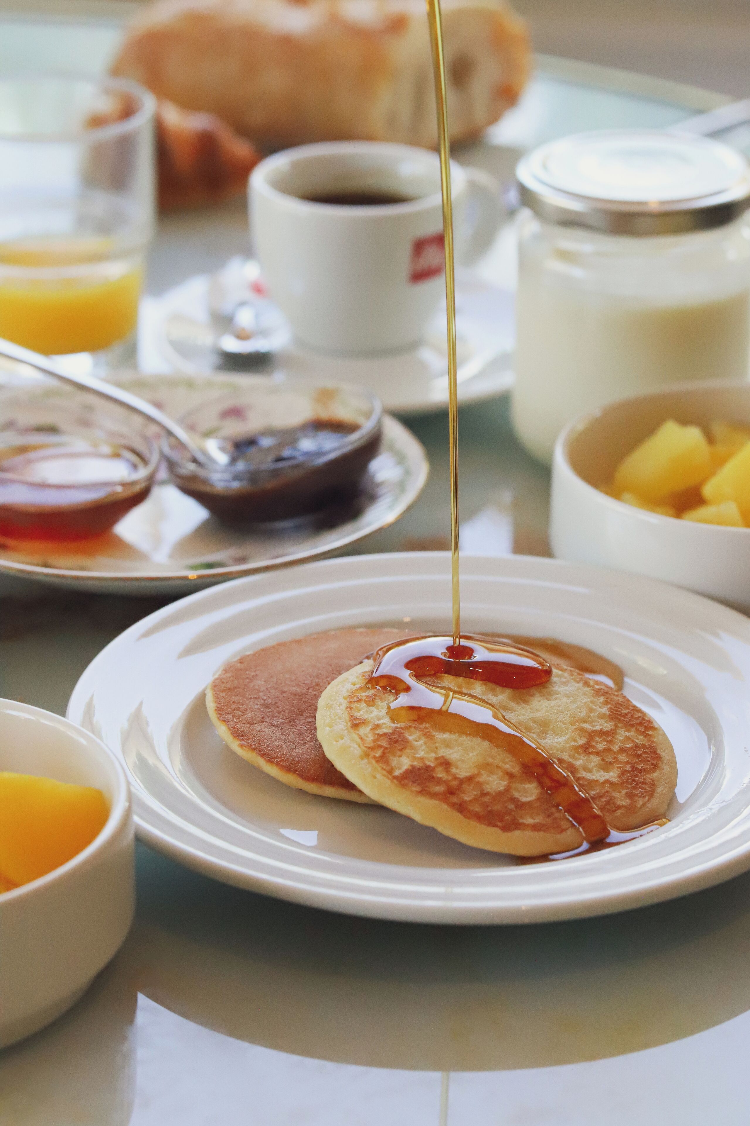 Desayuno con tortitas, jarabe y diferentes acompañamientos.