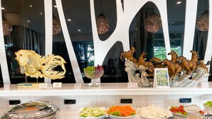 A buffet with various food items and decorative elements. - Grand Hill Resort and Spa (Nakhon Sawan)
