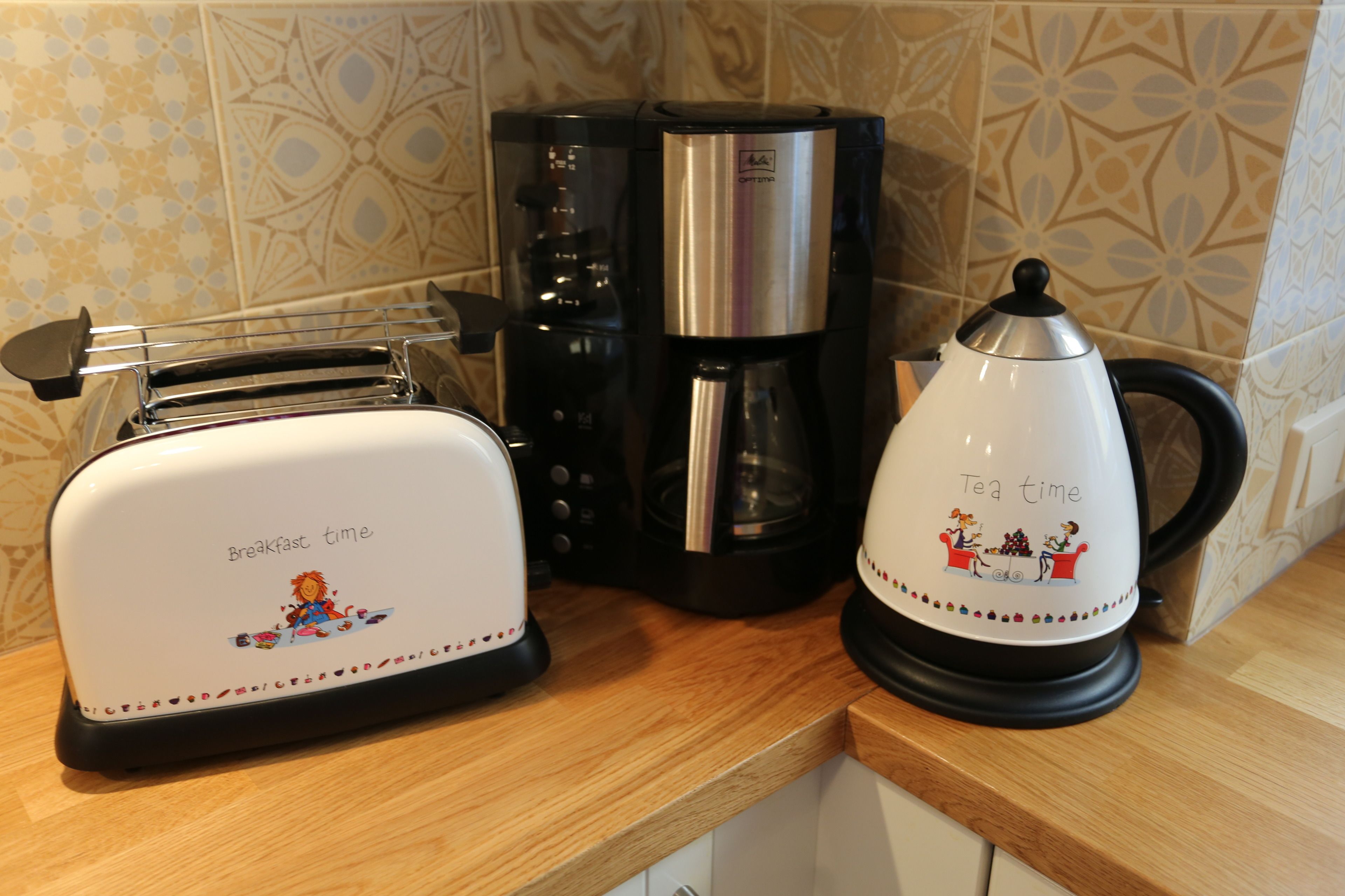 A kitchen counter with a toaster, a coffee maker, and a kettle.