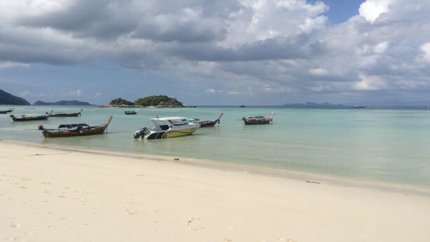A beach with several boats anchored near the shore.