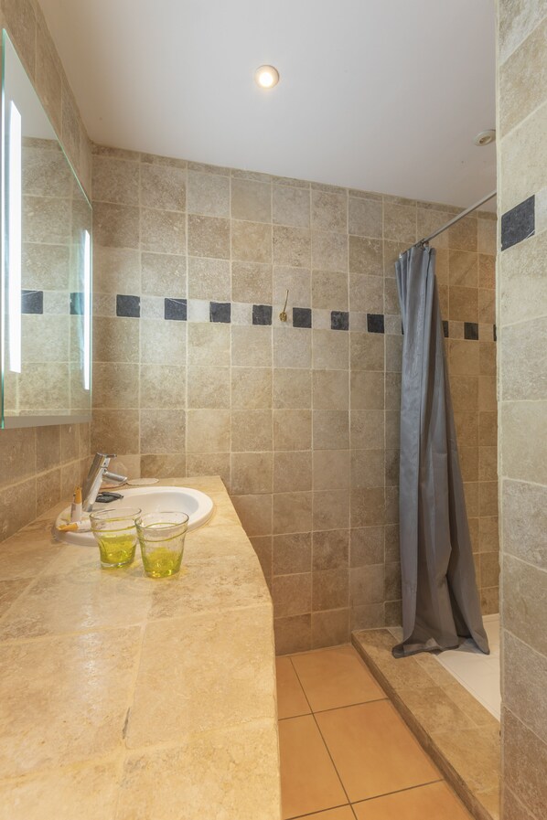 A bathroom with a sink, mirror, and shower curtain. - Alizés Hôtel (Cavalaire-sur-Mer)