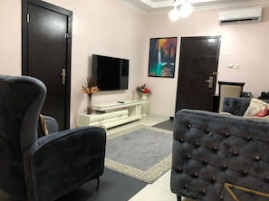 Suíte com design assinado, vista para a cidade | Área de estar | TV de tela plana