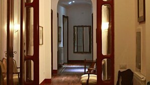 Un couloir doté d’un plancher en bois, d’un chambranle de porte en bois et d’un banc.