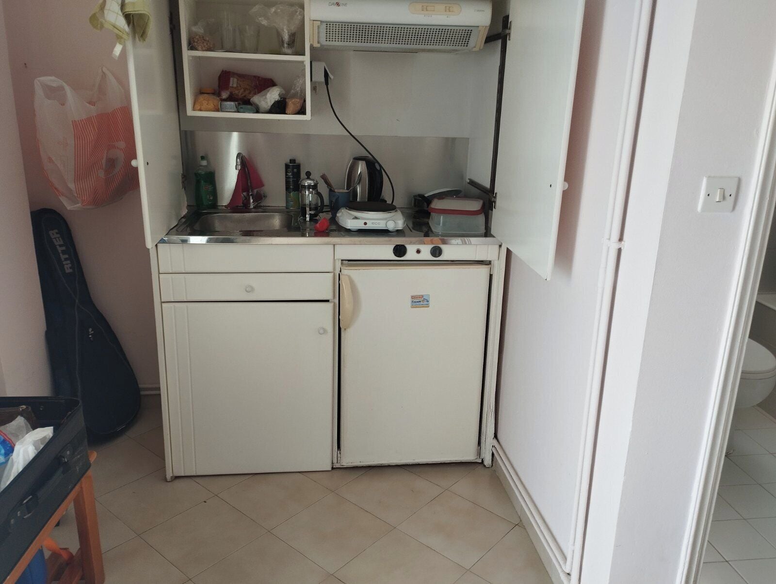 A compact kitchen with a refrigerator, sink, and a small countertop.