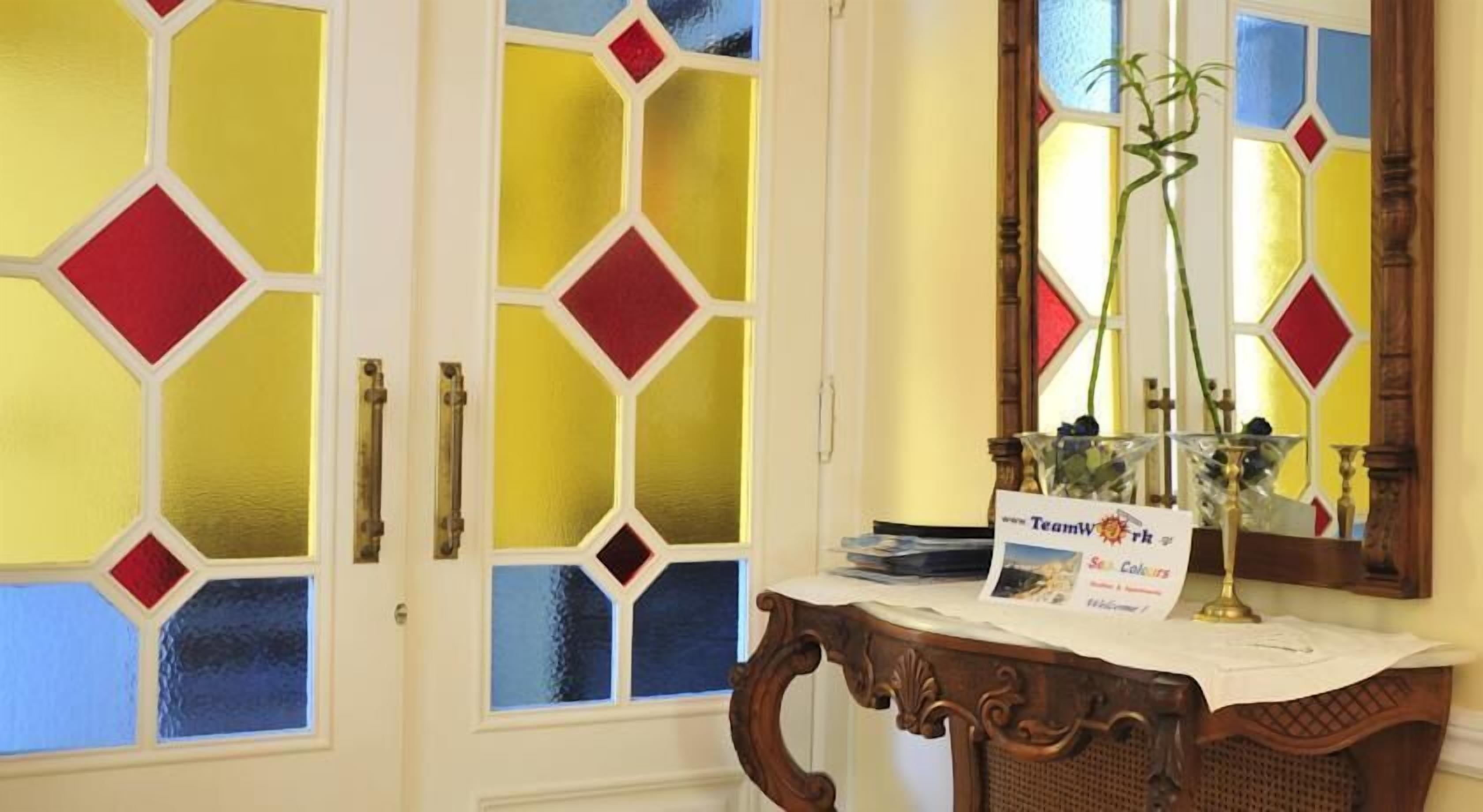 A room with a wooden desk, a mirror, and a sign reading "Teamwork Sea Colours."