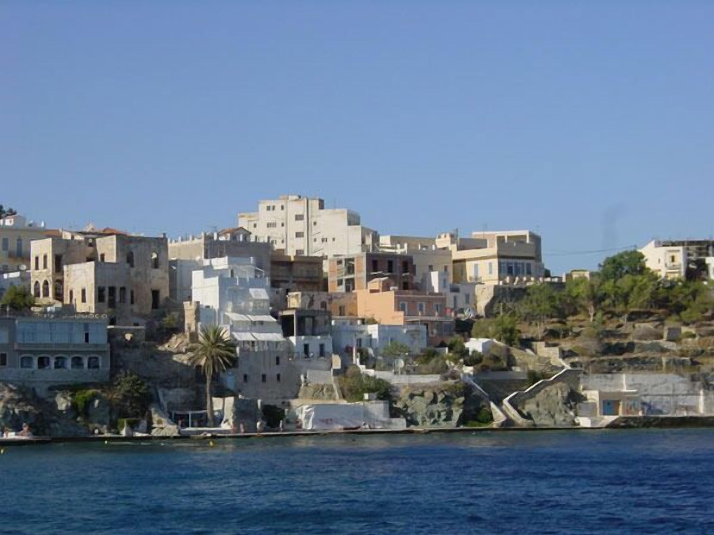 A coastal town with buildings built on a hillside overlooking the sea.