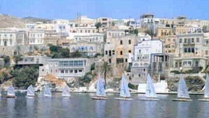 A coastal town with buildings along the waterfront and sailboats in the water.