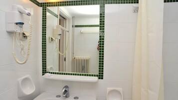 A bathroom with a urinal, a sink, a mirror, and a hairdryer mounted on the wall.