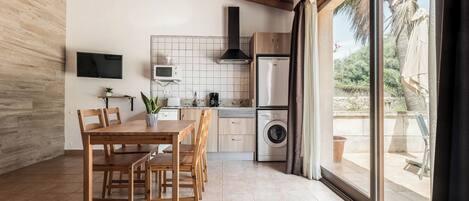Una cocina moderna con comedor, televisor montado en la pared y vistas al exterior.