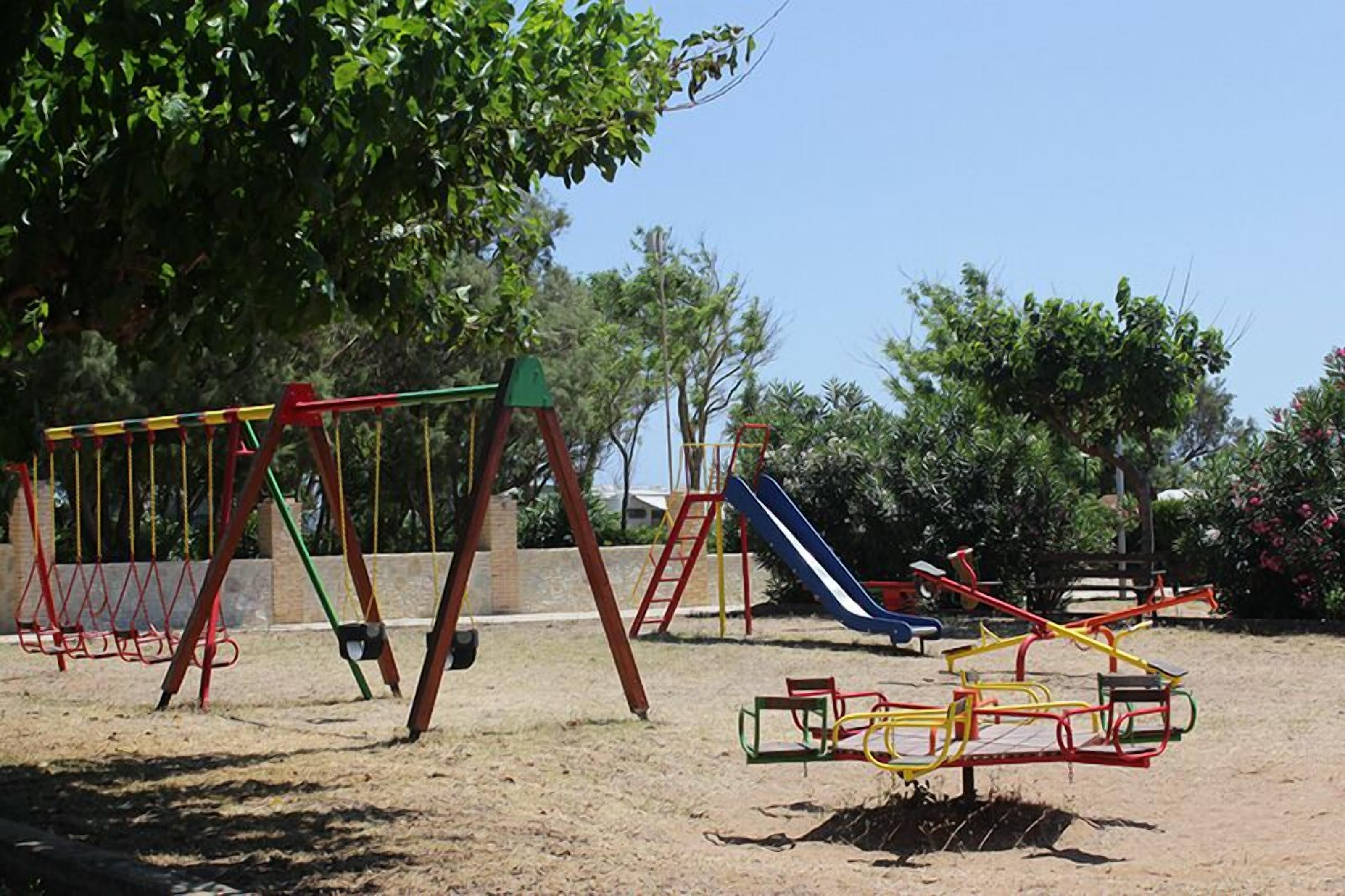A playground with swings, a slide, and a seesaw.