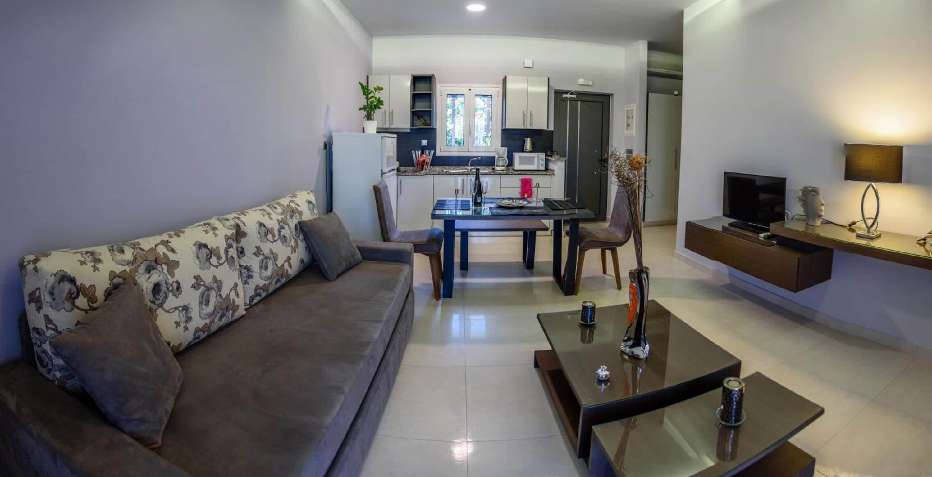 Una sala de estar moderna con sofá, mesa de centro y televisor.