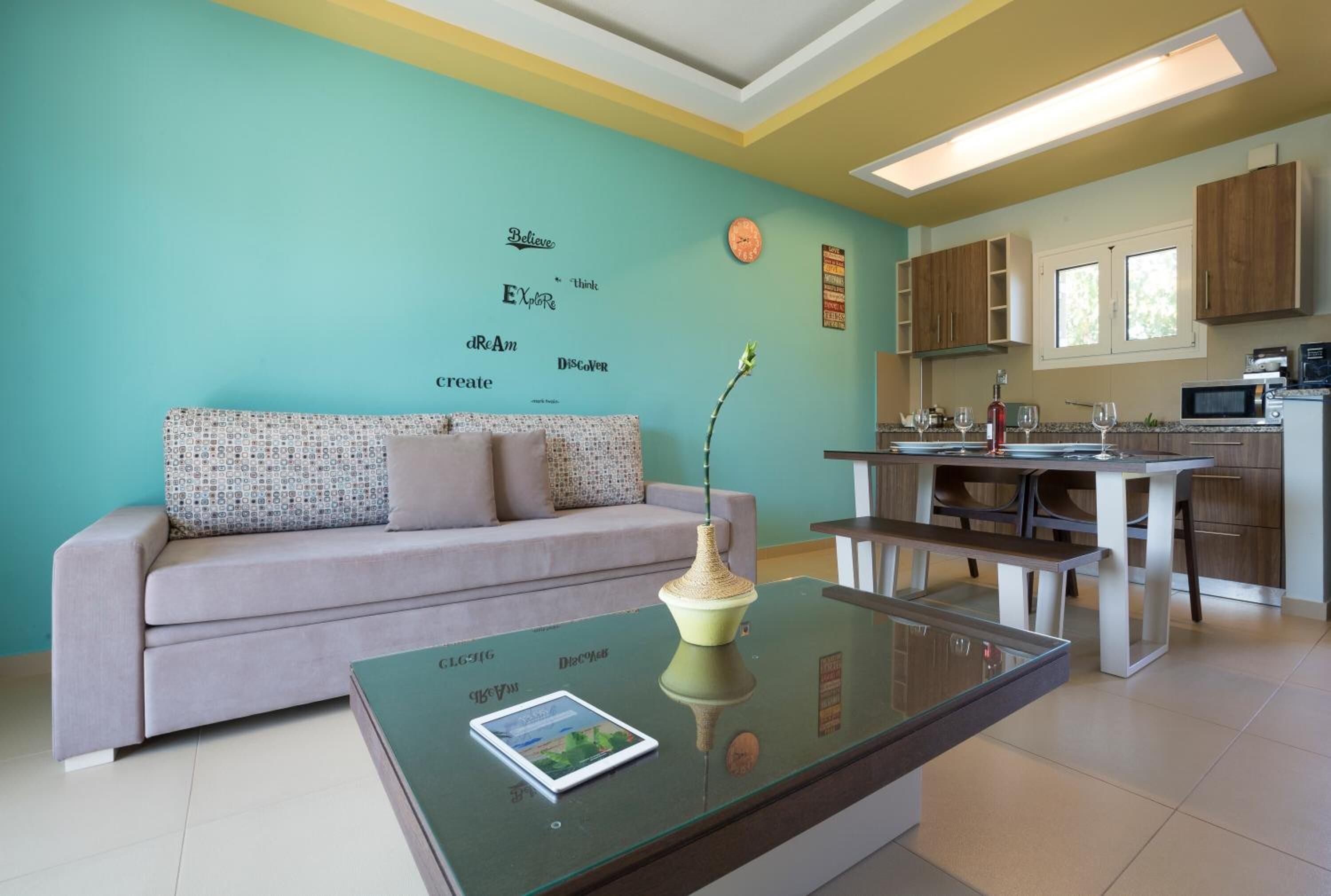 Una sala de estar moderna con un sofá, una mesa de centro de vidrio y una pared con citas motivacionales.