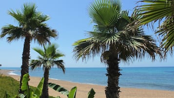 On the beach, white sand, sun loungers, beach umbrellas