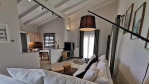 Una sala de estar moderna con sofá, comedor y cocina.