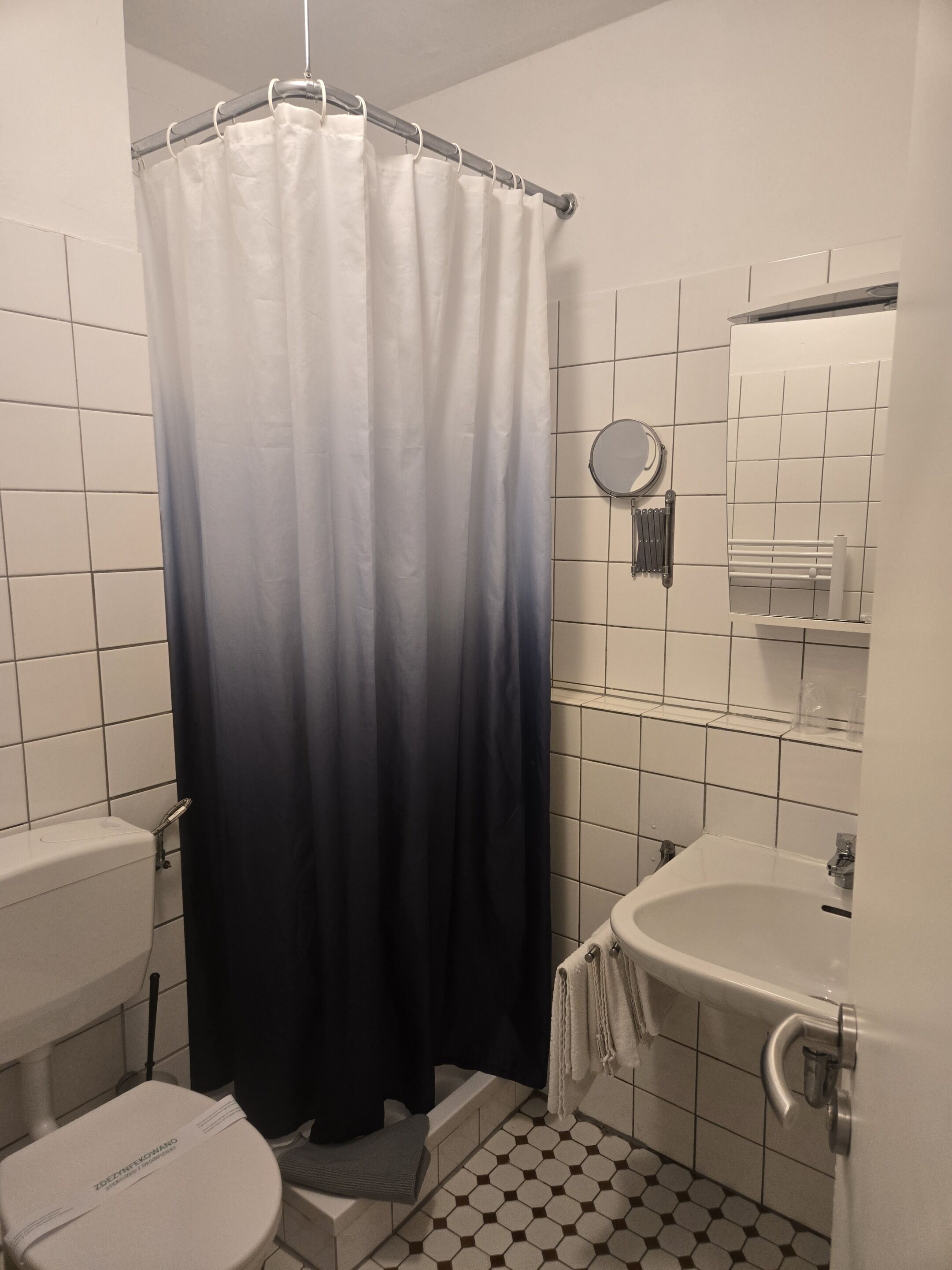 Ein Badezimmer mit Toilette, Waschbecken und Duschvorhang.