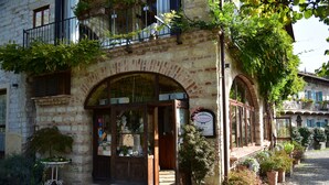 A stone building with a shop entrance, potted plants, and a small table outside. - Agriturismo Ca San Sebastiano Wine Resort & Spa (Camino)