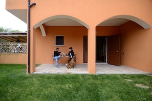 Un edificio de dos pisos con fachada naranja y un patio cubierto.