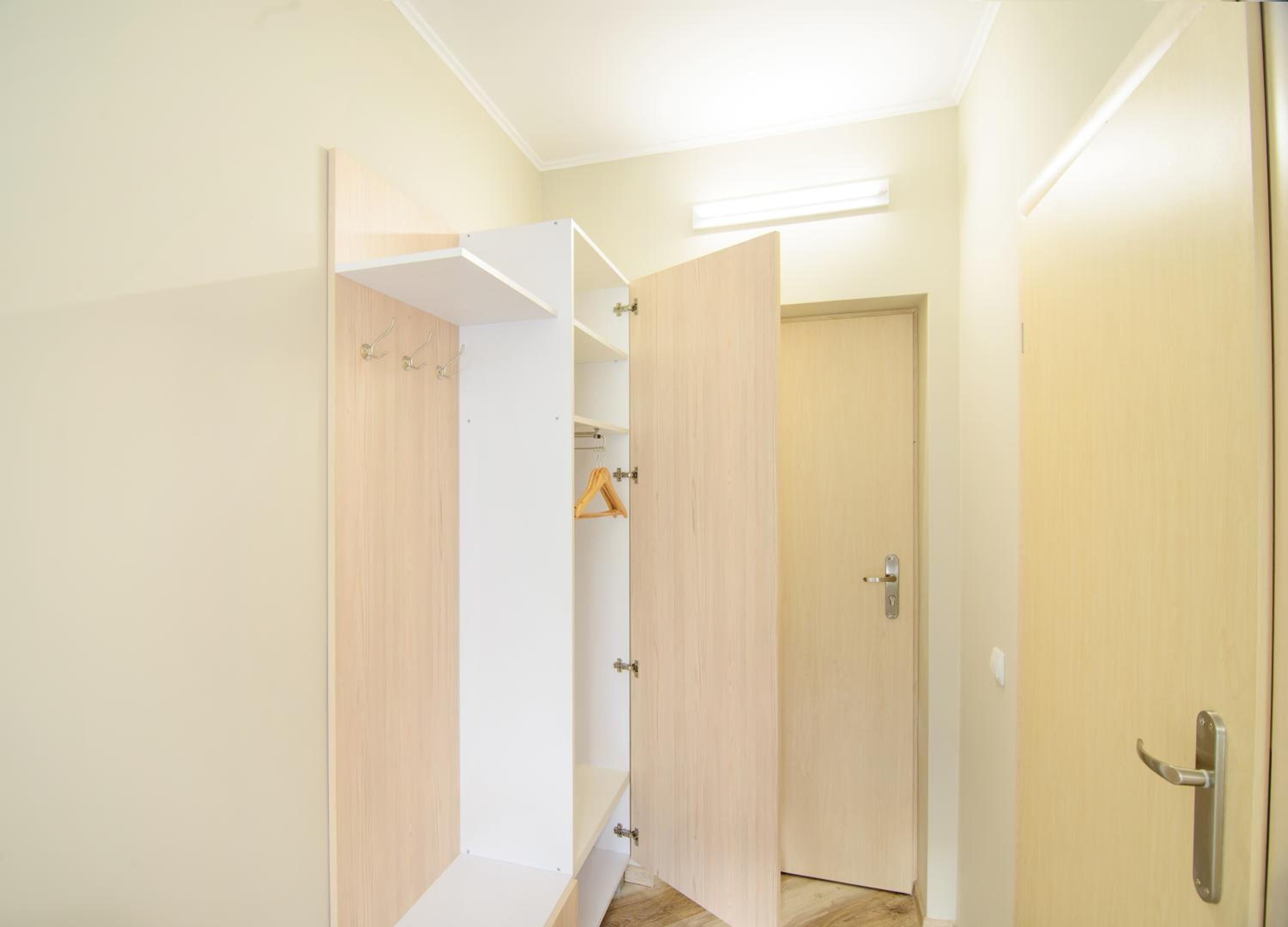 Un pasillo con un armario de madera y una puerta.