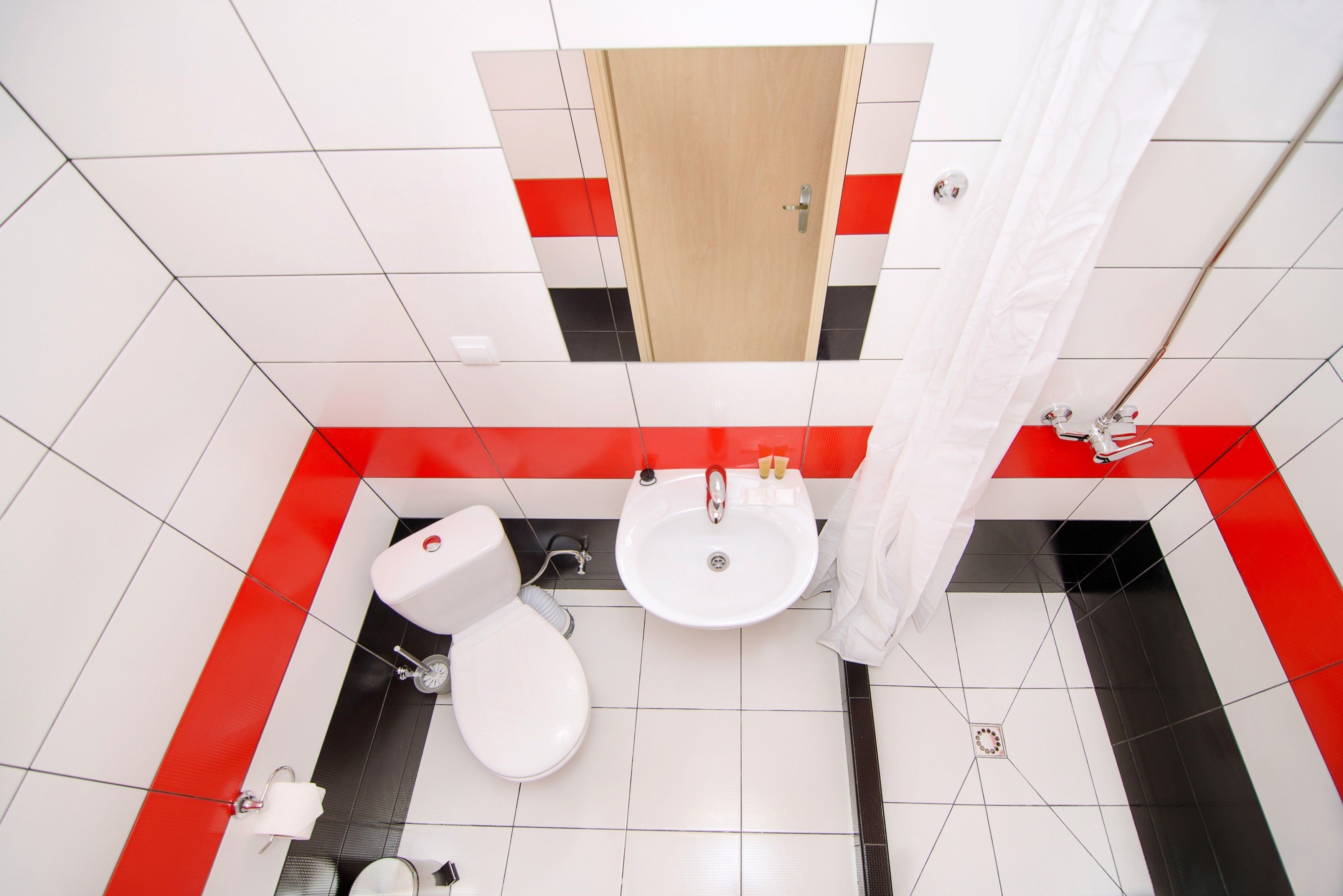 A bathroom with a toilet, sink, and shower curtain.
