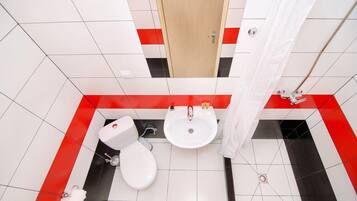 A bathroom with a toilet, sink, and shower curtain.