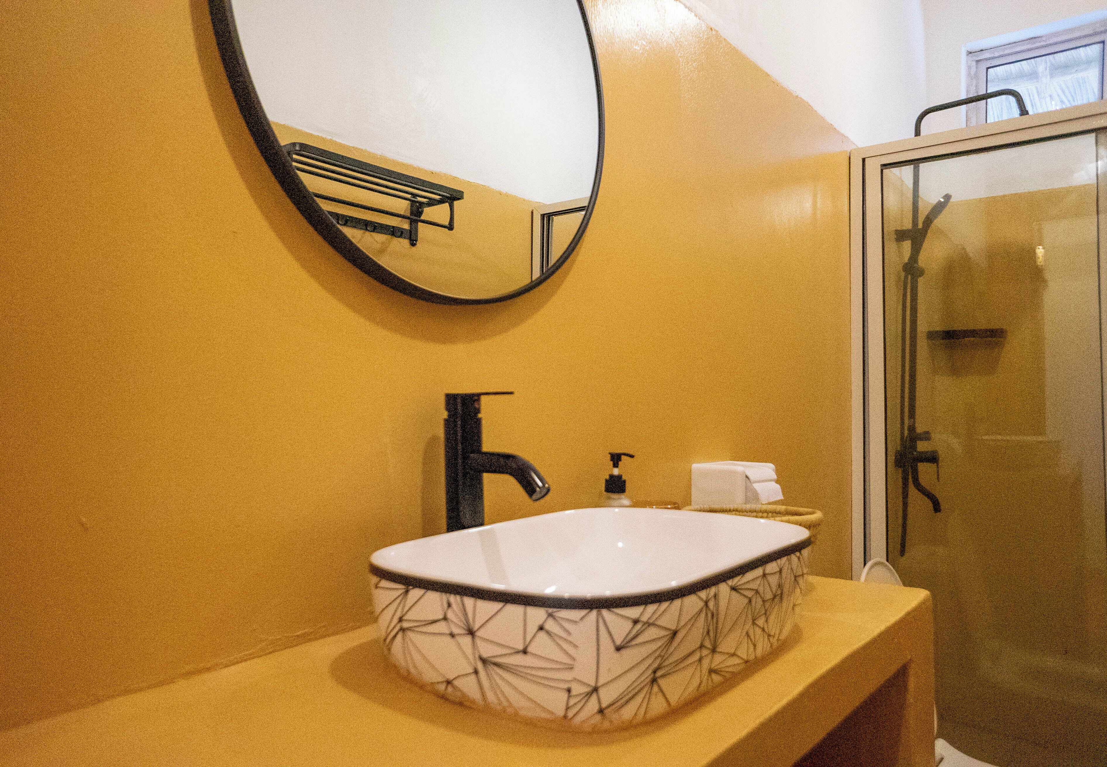 A bathroom with a white sink, black faucet, and a mirror above it.