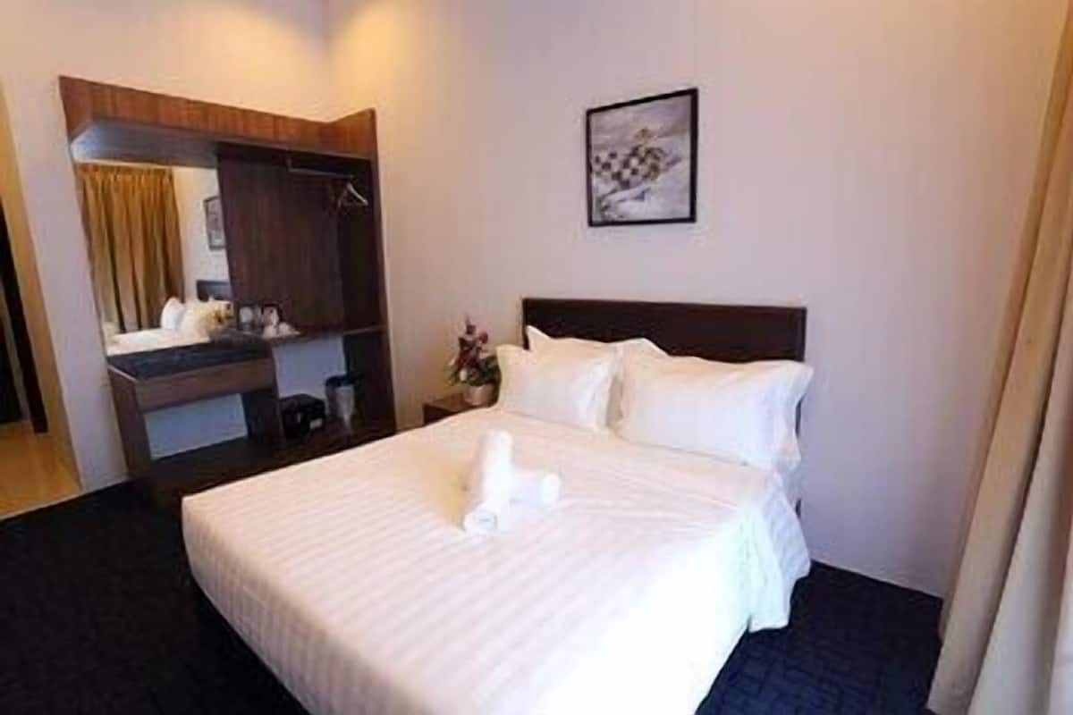 Una habitación de hotel con una cama, un tocador, un espejo y un cuadro en la pared.