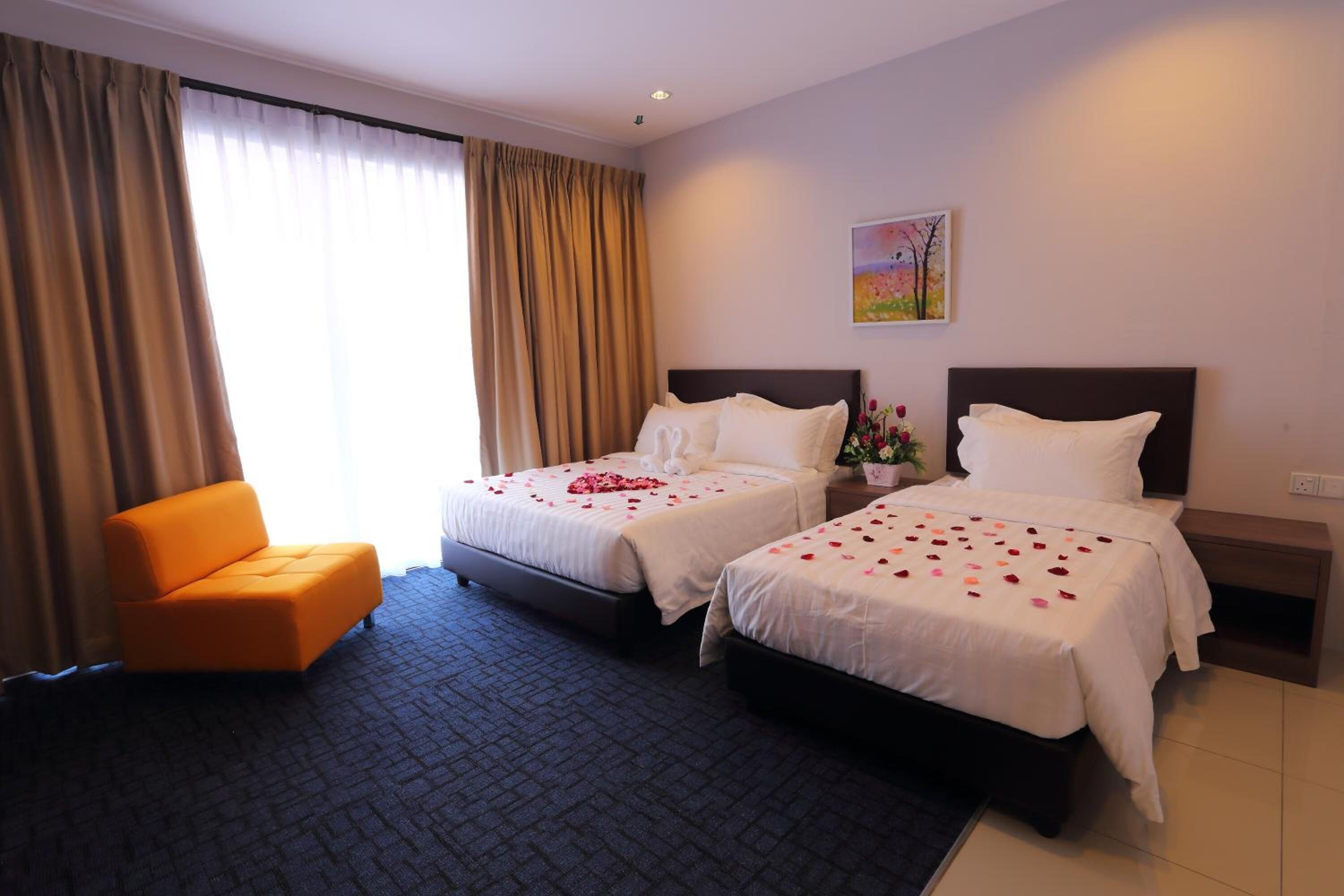 Habitación de hotel con dos camas, un sofá y un cuadro en la pared.