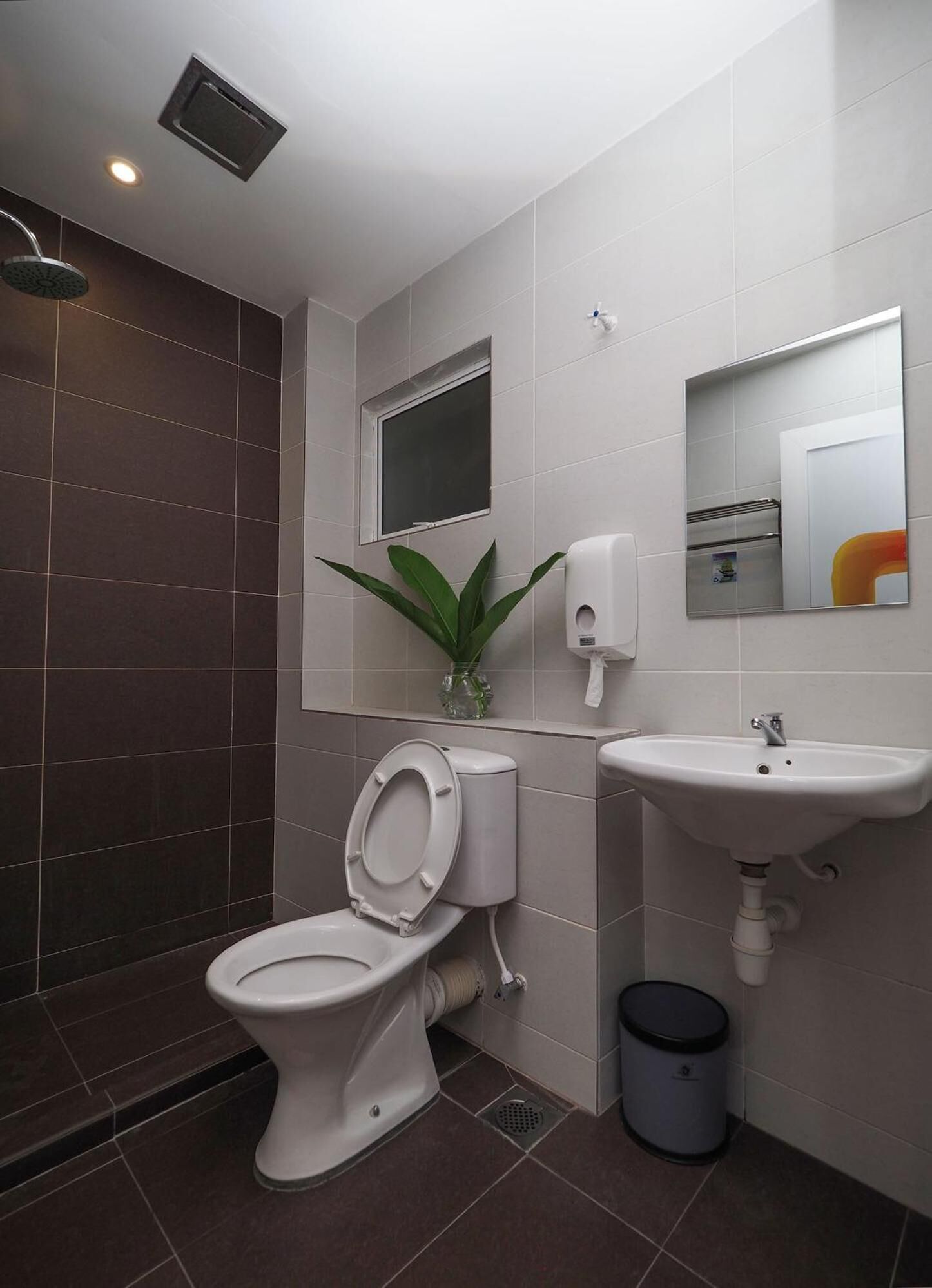 A modern bathroom with a toilet, sink, and shower.