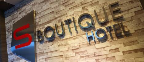 Un cartel para 'Boutique Hotel' con un diseño moderno y un llamativo logo en forma de 'S'.