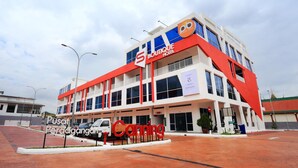 Um hotel moderno com fachada marcante em vermelho e branco, entrada visível e placa indicando ser um hotel boutique.