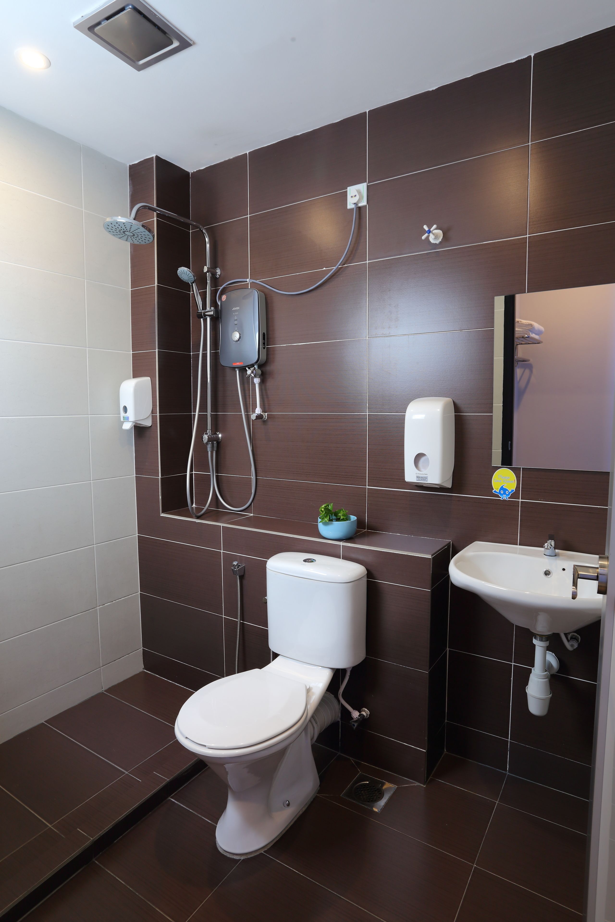 A modern bathroom with a shower, toilet, and sink.