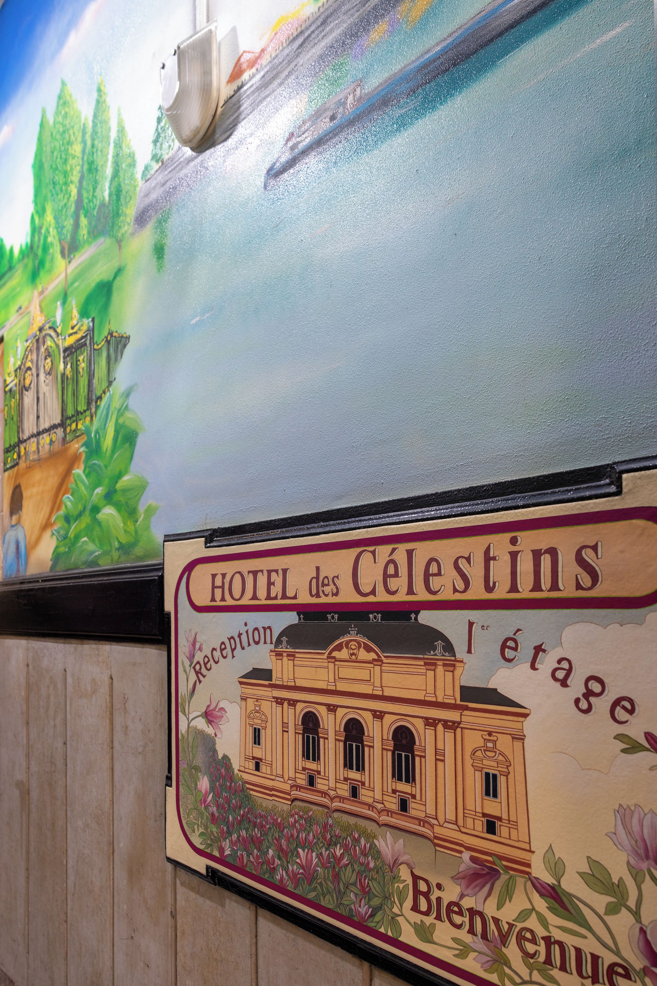 Hotellin kyltti, jossa lukee »HOTEL des Célestins», sekä vastaanottoalue.