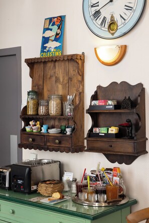 A kitchen with wooden cabinets, a clock, and various kitchen items. - Hôtel des Célestins (Lyon)