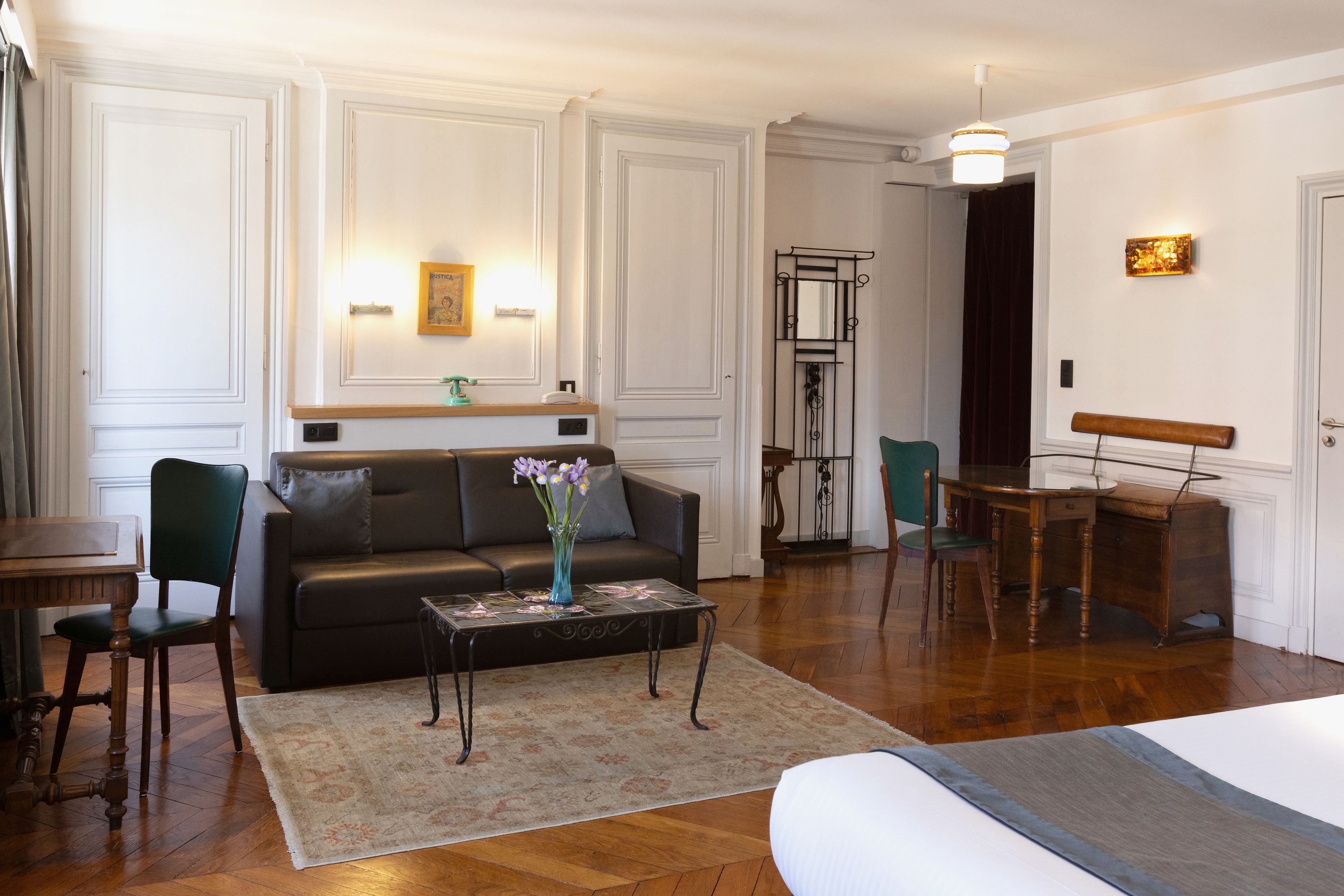 A well-lit room with a sofa, a coffee table, a dining table, and a chair.