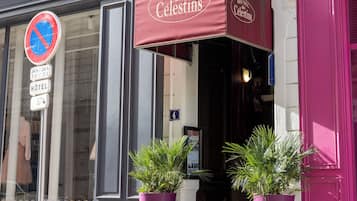 A hotel sign with 'HOTEL des Celestins' and a no parking sign.