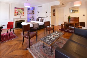Una habitación de hotel moderna con cama, zona de estar y chimenea.