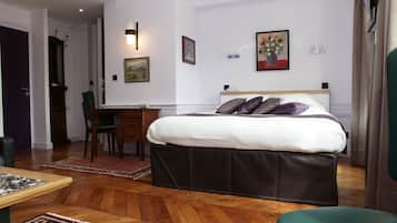 Habitación de hotel con cama, escritorio, silla y vista al pasillo.