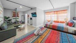 A modern hotel room with a large bed, a sofa, a dining area, and a kitchen. - Rock Apartments by Lowkl (Miami Beach)