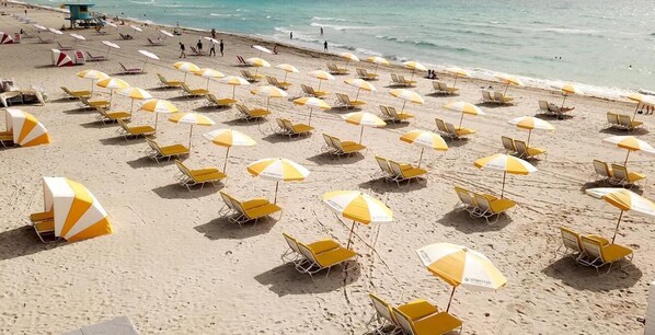 Una playa cerca, sillas reclinables de playa, toallas de playa