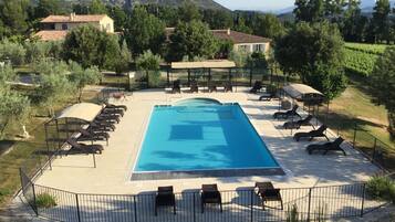 Relax by the serene pool surrounded by lush greenery and rolling hills.