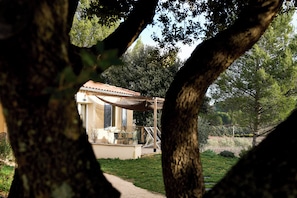 A rustic building with a tiled roof, surrounded by trees and grass. - Le Clos Saint-Michel & Spa (Malaucene)