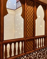 Un panel de madera con tallas elaboradas y un balcón con barandilla decorativa.