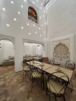 Un comedor con una mesa larga, sillas y un sofá.