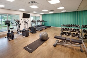 A gym with treadmills, elliptical machines, a stationary bike, a rowing machine, a bench press, and a rack of dumbbells. - Holiday Inn Express & Suites Terrace by IHG (Terrace)