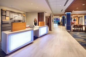 A hotel reception area with a modern design, featuring a reception desk, a waiting area, and a visible staircase leading to other floors. - Holiday Inn Express & Suites Terrace by IHG (Terrace)