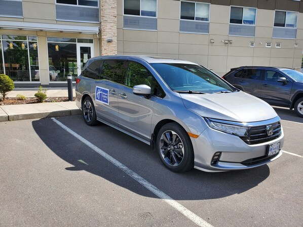 A silver minivan parked in a lot with a sign indicating it is a Holiday Inn Express & Suites. - Holiday Inn Express & Suites Terrace by IHG (Terrace)
