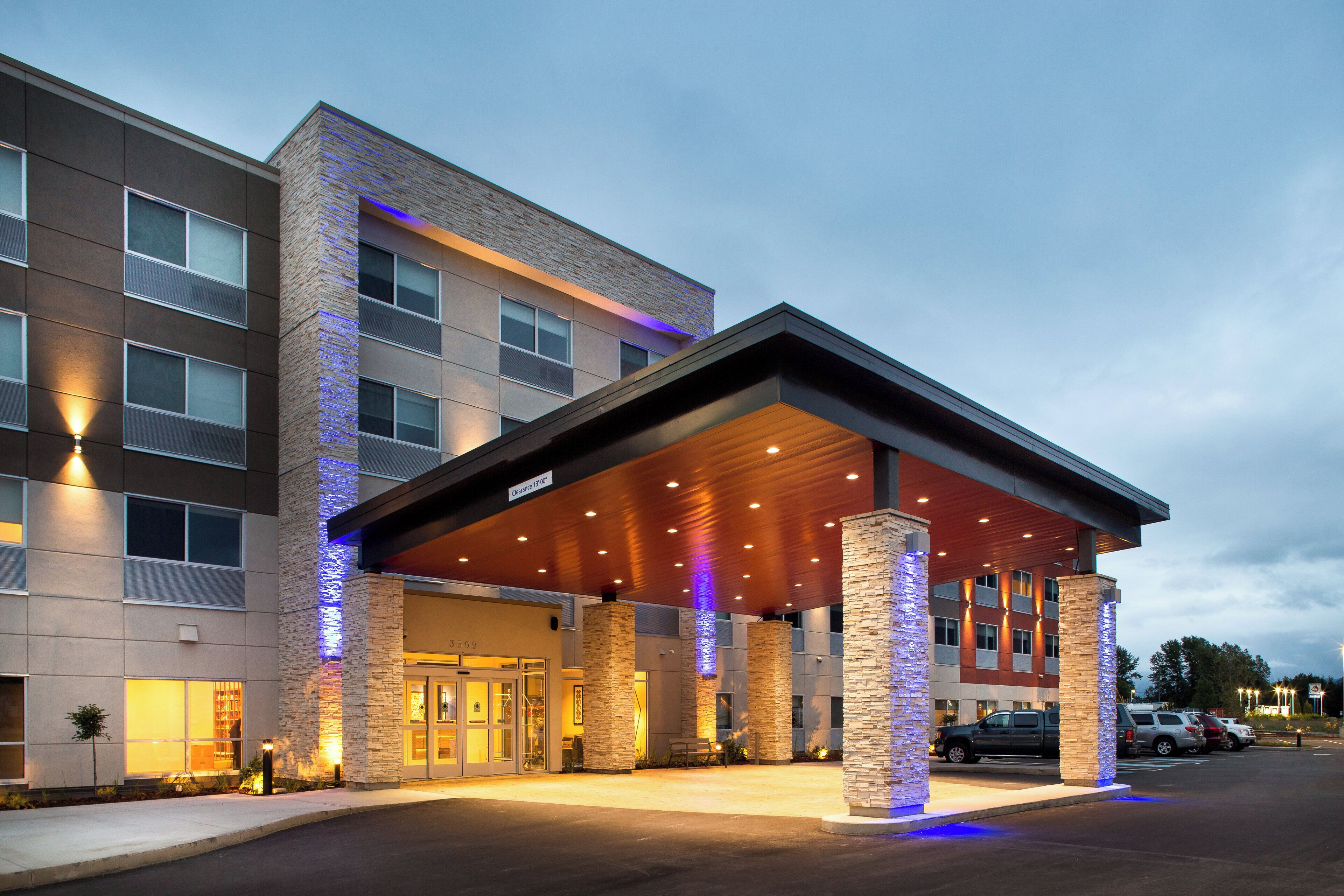 A hotel with a covered entrance, multiple windows, and a stone facade.