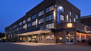 A multi-story hotel with a 'Welcome' entrance and a 'Taco Mama' restaurant on the ground floor. - Hampton Inn Huntsville/Village of Providence (Huntsville)