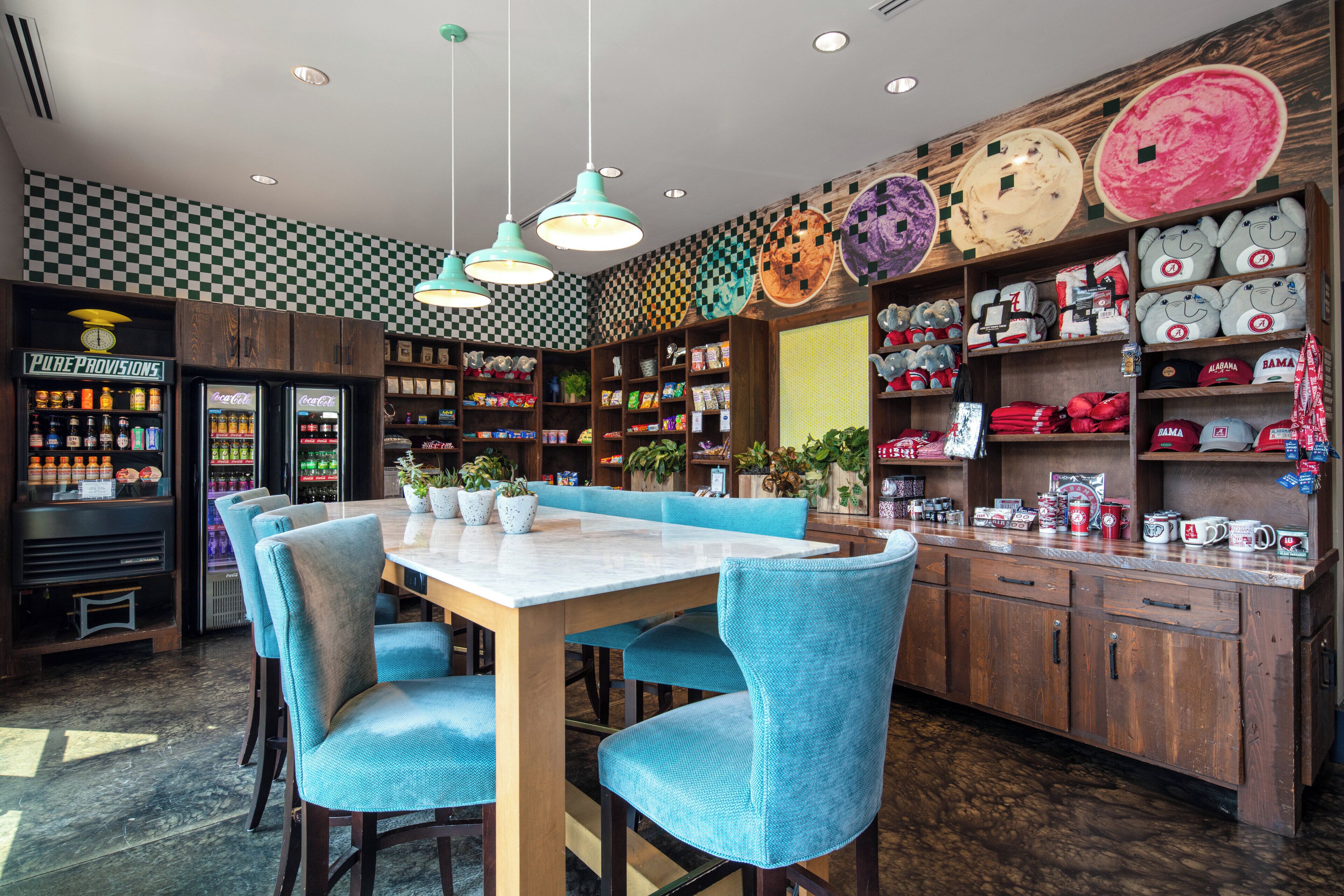A restaurant with a checkered wall, a wooden counter, and blue chairs.