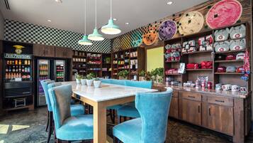 A restaurant with a checkered wall, a wooden counter, and blue chairs.